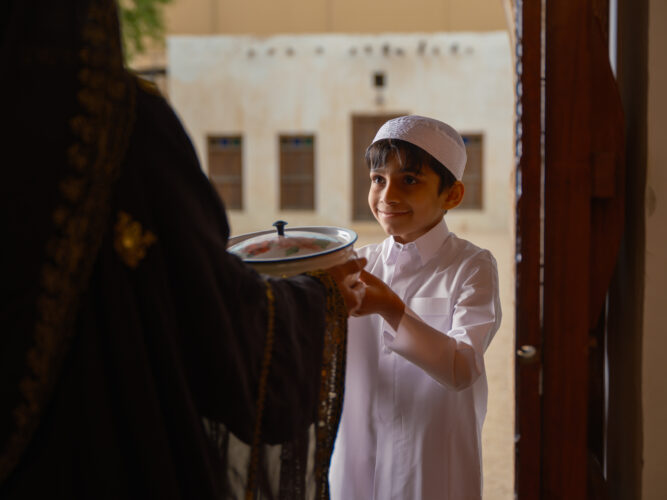 طفل قطري يعطي الطعام لجيرانه